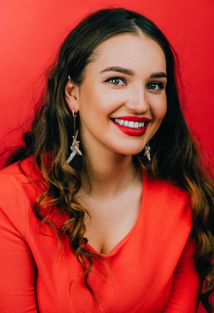 Foto retrato de uma jovem sorridente contra um fundo vermelho