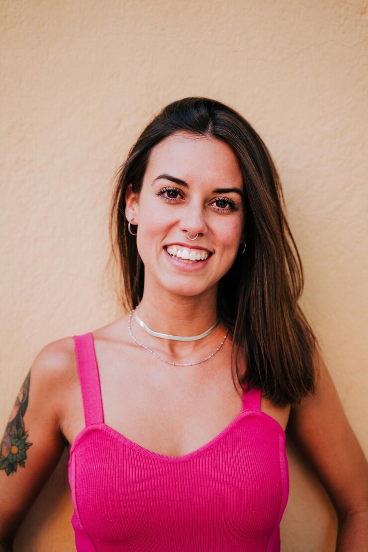 Foto retrato de uma jovem sorridente contra uma parede rosa