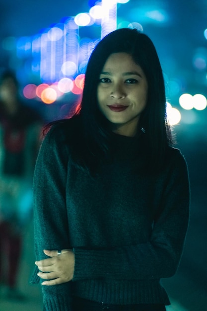 Retrato de uma jovem sorridente de pé à noite
