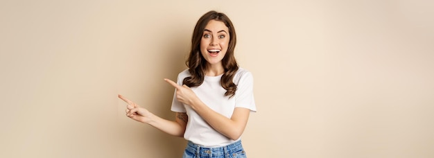 Foto retrato de uma jovem sorridente de pé contra a parede