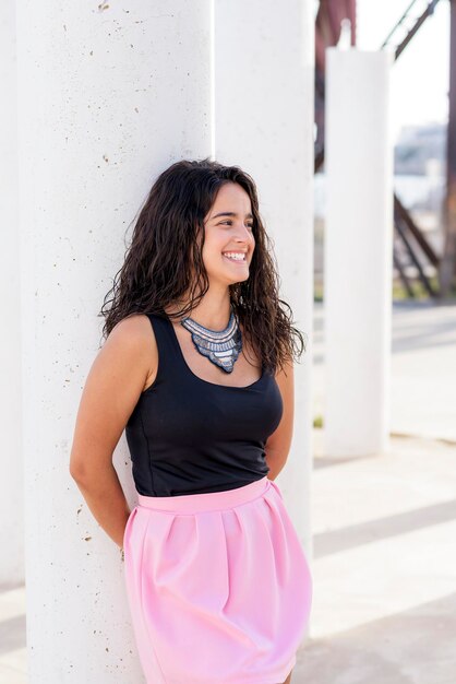 Foto retrato de uma jovem sorridente de pé contra a parede