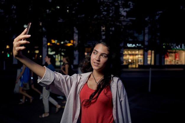 Retrato de uma jovem sorridente de pé contra as árvores