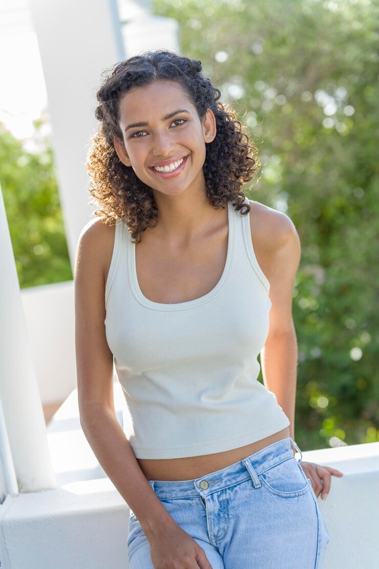 Foto retrato de uma jovem sorridente de pé contra as árvores