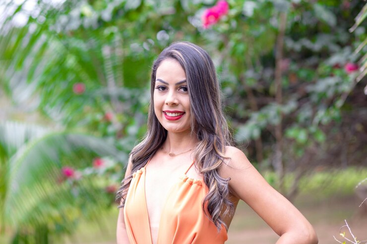 Foto retrato de uma jovem sorridente de pé contra as plantas