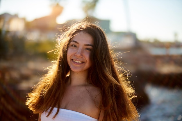 Retrato de uma jovem sorridente de pé contra o céu