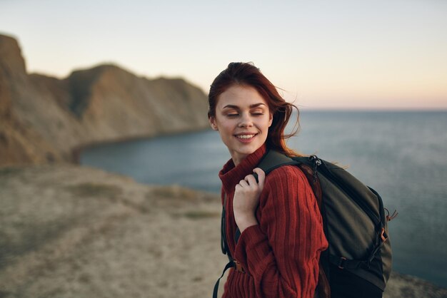 Foto retrato de uma jovem sorridente de pé contra o mar