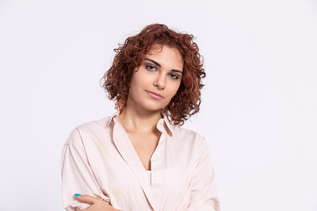 Foto retrato de uma jovem sorridente de pé contra um fundo branco