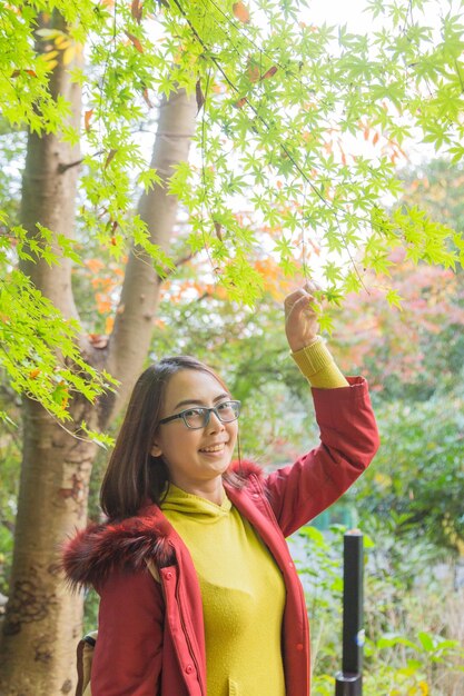 Foto retrato de uma jovem sorridente de pé junto a plantas