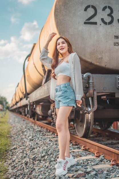 Foto retrato de uma jovem sorridente de pé no trilho ferroviário