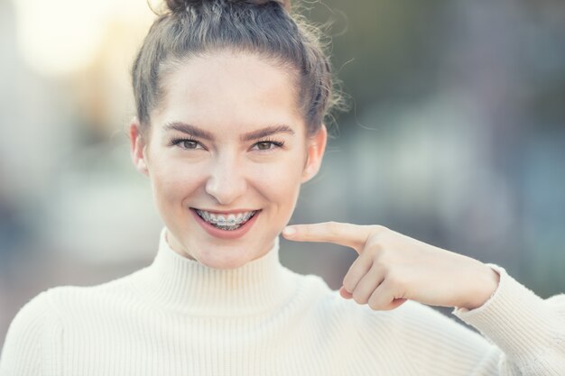 Retrato de uma jovem sorridente e feliz com aparelho dentário.