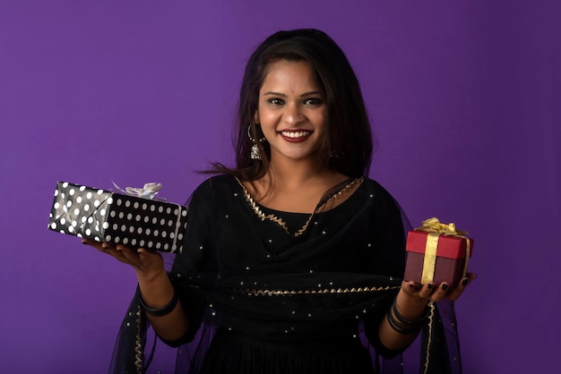 Retrato de uma jovem sorridente feliz ou menina segurando a caixa de presente