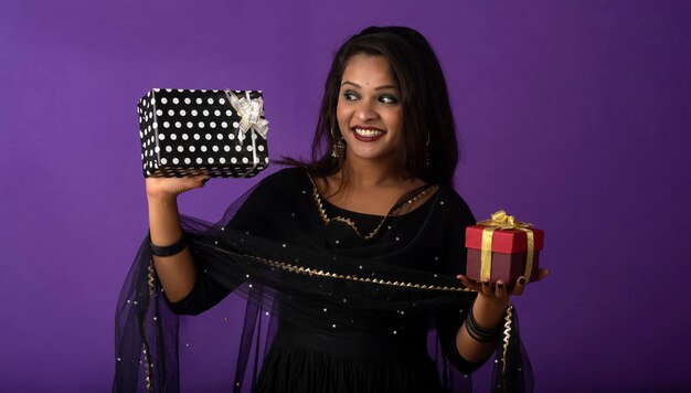 Foto retrato de uma jovem sorridente feliz ou menina segurando a caixa de presente