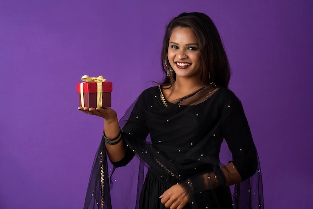 Retrato de uma jovem sorridente feliz ou menina segurando a caixa de presente