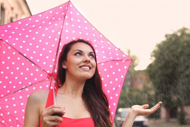 Foto retrato de uma jovem sorridente na chuva