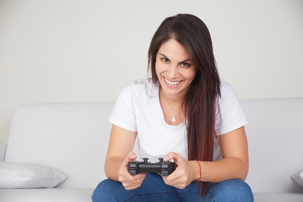Retrato de uma jovem sorridente segurando o controle remoto de um videogame