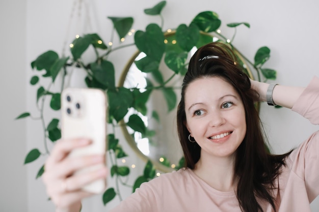 Retrato de uma jovem sorridente segurando smartphone fazendo selfie ou bate-papo por vídeo