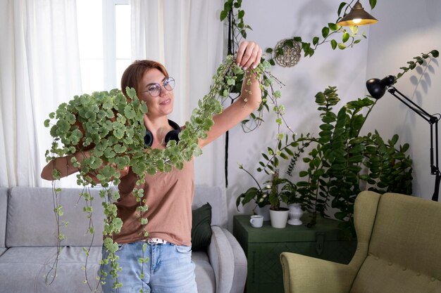 Retrato de uma jovem sorridente segurando uma planta em vaso