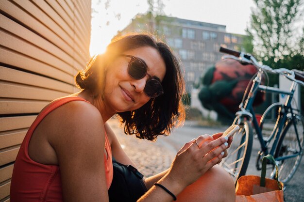 Foto retrato de uma jovem sorridente sentada ao ar livre