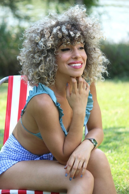 Foto retrato de uma jovem sorridente sentada ao ar livre