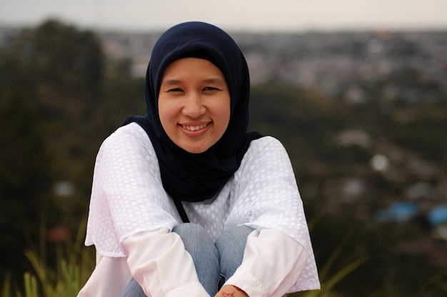 Retrato de uma jovem sorridente sentada ao ar livre