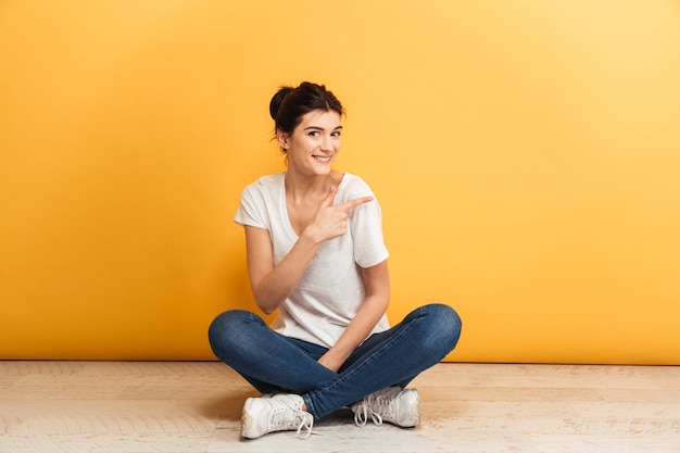 Retrato de uma jovem sorridente, sentada com as pernas cruzadas