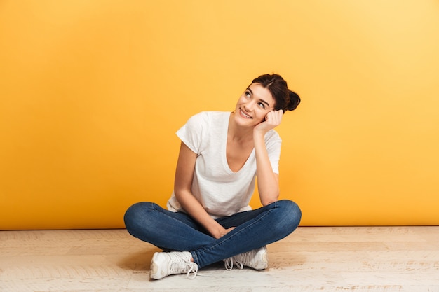 Retrato de uma jovem sorridente, sentada com as pernas cruzadas