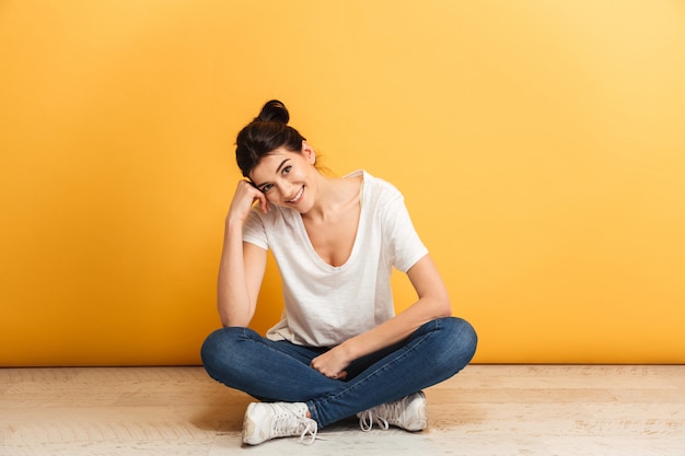 Retrato de uma jovem sorridente, sentada com as pernas cruzadas