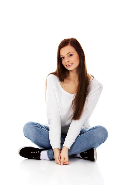 Retrato de uma jovem sorridente sentada contra um fundo branco