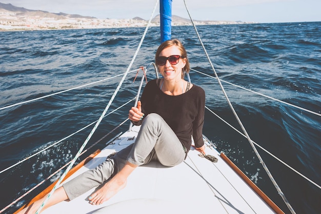 Retrato de uma jovem sorridente sentada em um barco no mar