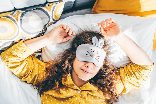 Foto retrato de uma jovem sorridente sentada na cama