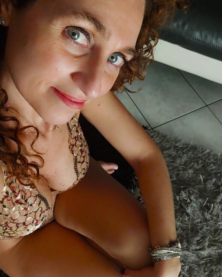Foto retrato de uma jovem sorridente sentada no chão.