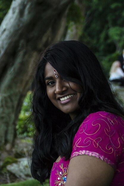 Foto retrato de uma jovem sorridente sentada no parque