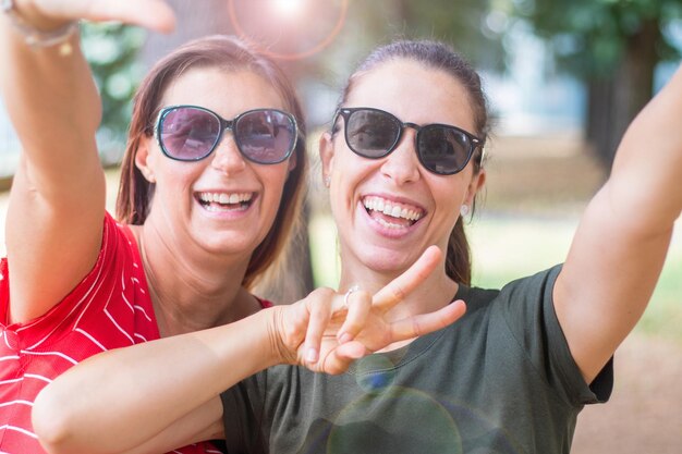 Foto retrato de uma jovem sorridente usando óculos de sol