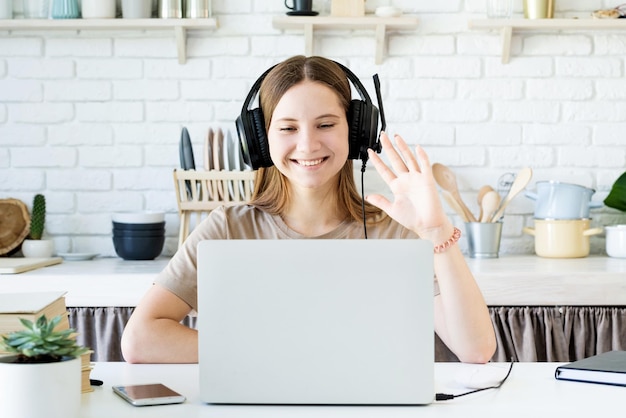 Retrato de uma jovem sorridente usando um laptop na mesa