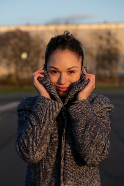 Retrato de uma jovem sorridente vestindo um casaco ao ar livre