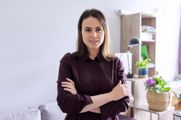 Retrato de uma jovem terapeuta social mental feminino confiante com os braços cruzados no escritório. Psicologia, psicoterapia, saúde mental, conceito de ajuda e suporte