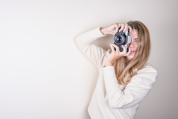 Retrato de uma jovem tirando fotos com uma câmera profissional