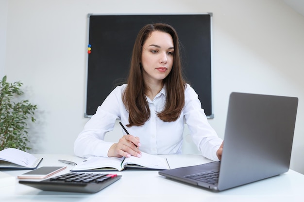 Retrato de uma jovem trabalhando em seu laptop no escritório