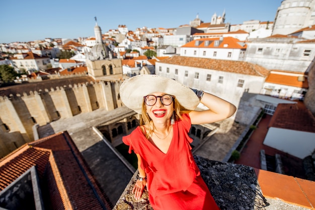 Retrato de uma jovem turista com vestido vermelho no fundo da cidade velha, viajando pela cidade de coimbra, no centro de portugal
