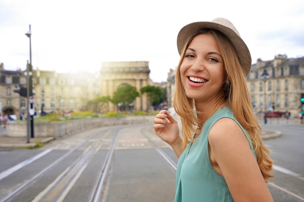 Retrato de uma jovem turista sorridente olha para a câmera na ponte Pont de pierre em Bordeaux França