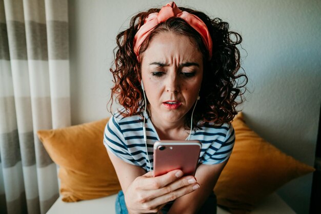 Foto retrato de uma jovem usando o telefone em casa