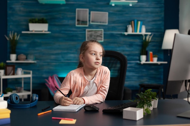 Foto retrato de uma jovem usando o telefone enquanto está sentada na mesa