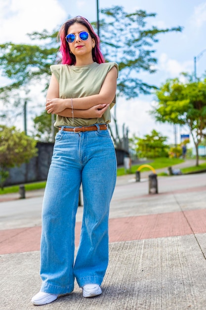 Retrato de uma jovem usando óculos de sol de pé ao ar livre