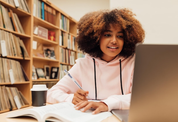 Foto retrato de uma jovem usando um laptop em casa