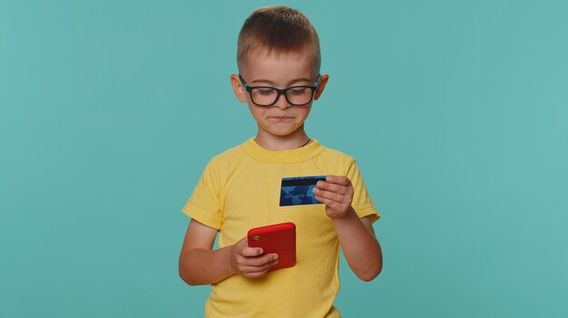 Foto retrato de uma jovem usando um telefone celular contra um fundo azul