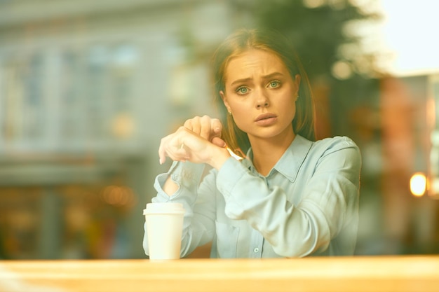 Retrato de uma jovem usando um telefone celular em um café