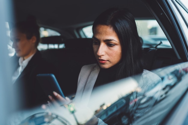 Retrato de uma jovem usando um telefone celular enquanto estava sentada no carro