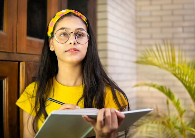 Foto retrato de uma jovem usando um telefone inteligente ao ar livre