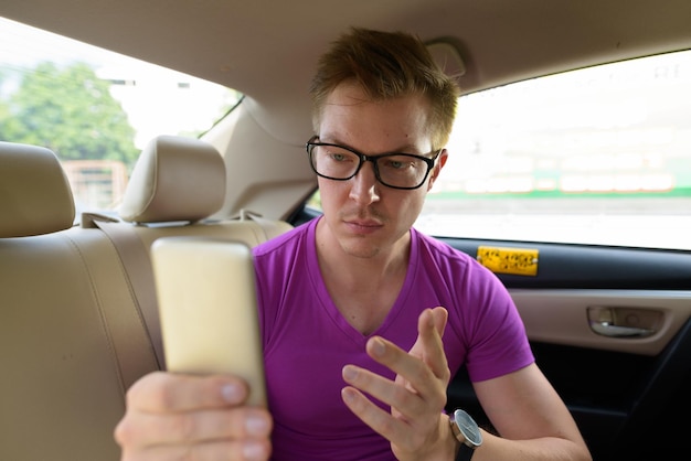 Retrato de uma jovem usando um telefone inteligente no carro