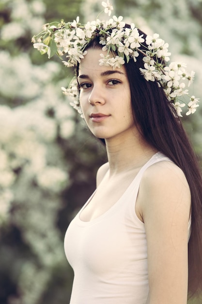 Retrato de uma jovem vestindo flores enquanto está de pé no parque